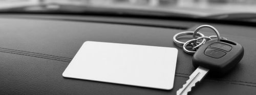 Insurance card and car keys on a dashboard